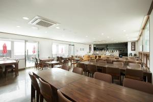 a dining room with wooden tables and chairs at Hotel California in Seogwipo