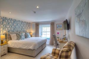 a bedroom with a bed and a desk and a chair at Bertram's in Warkworth