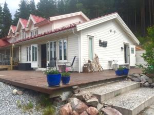 een klein wit huis met een houten terras bij Apartment - Lille Galleri - Fyresdal in Fyresdal