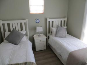 two beds sitting next to each other in a bedroom at Pearly Beach Cottage in Pearly Beach