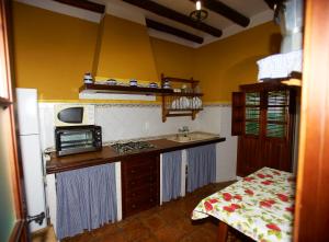 a small kitchen with a counter and a microwave at Casa Rural Casa Ronda in El Bosque
