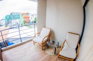 墾丁的住宿－棕櫚小築渡假旅店，阳台配有两把椅子和一张桌子,还有一个窗户。