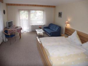 ein Schlafzimmer mit einem Bett und einem blauen Stuhl in der Unterkunft Landhaus Enztalperle in Enzklösterle