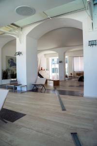 a large room with white walls and wooden floors at Hotel Amyclae in Sperlonga