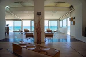 a room with a table and chairs and the ocean at Hotel Amyclae in Sperlonga