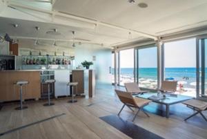 a living room with a table and a view of the ocean at Hotel Amyclae in Sperlonga