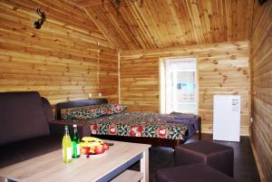 a log cabin with a bed and a table with drinks at Marinus in Gribovka