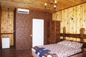 a bedroom with a bed in a room with wooden walls at Marinus in Gribovka