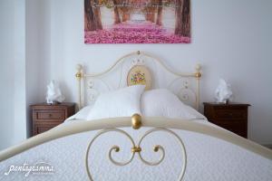 アルベロベッロにあるB&B Pentagrammaのベッドルーム1室(白いベッド1台、ナイトスタンド2台付)