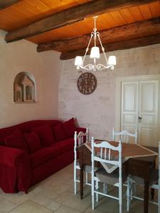 a living room with a red couch and a table at Resort Romano in Trulli in Alberobello