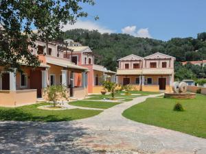 une rangée de maisons avec une pelouse et des arbres dans l'établissement Erikousa Villas by CorfuEscapes, à Ereikoússa