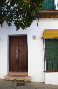 a wooden door on the side of a white building at Casa Rural Casa Ronda in El Bosque