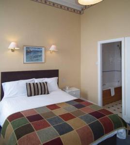フリートウッドにあるThe North Euston Hotelのベッドルーム1室(カラフルな毛布付きのベッド1台付)