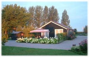 a house with a bunch of white flowers in front of it at Fruitbedrijf Stek in Kedichem