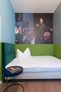 a bed in a room with a poster of men at Hotel Beethoven Wien in Vienna