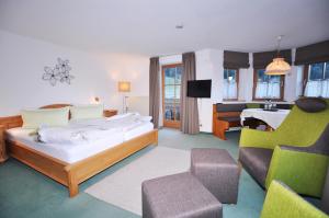 a hotel room with a bed and a living room at Berghüs Schratt - EINFACH ANDERS - Ihr vegetarisches und veganes Biohotel in Oberstaufen