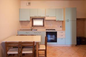 a kitchen with white cabinets and a table with chairs at Lauri & Faggi in Desenzano del Garda