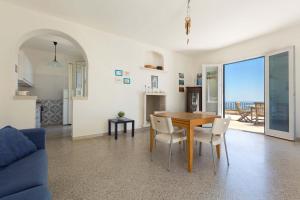 - une salle à manger et un salon avec une table et des chaises dans l'établissement Terrazza sul mare by BarbarHouse, à Santa Cesarea Terme
