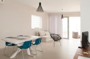 a white living room with a table and chairs at ILIOS H&E house in Elia Laconias