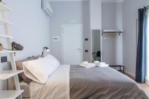 a bedroom with a large bed with white pillows at Cortile Umberto I in Cefalù