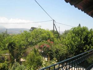 a balcony of a house with trees and flowers at Dimis Country House in Arménoi