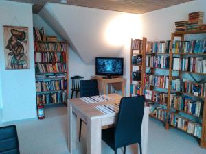 a dining room with a table and bookshelves at Bed and Breakfast Hasseloe in Nykøbing Falster