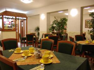 a dining room with tables and chairs with yellow dishes on them at Penzion Martin in Janske Lazne