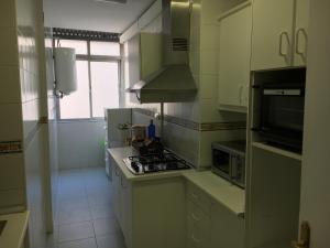 a small kitchen with a stove and a microwave at ¡Plaza de la Merced! in Málaga
