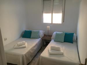 two twin beds in a room with a window at ¡Plaza de la Merced! in Málaga