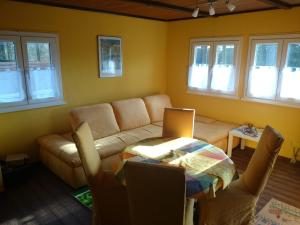 ein Wohnzimmer mit einem Sofa und einem Tisch in der Unterkunft Ferienhaus Thom in Neubäu am See in Neubäu