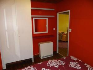 ein rotes Zimmer mit einem Bett und einem Spiegel in der Unterkunft Ferienhaus Thom in Neubäu am See in Neubäu