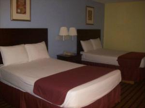um quarto de hotel com duas camas e duas lâmpadas em Fairway Inn La Porte em La Porte