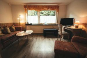 a living room with a couch and a desk with a computer at Hotel-Restaurant Walkmühle in Usingen