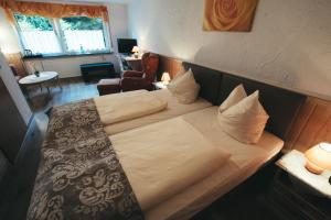 UsingenにあるHotel-Restaurant Walkmühleのベッドルーム(白いシーツを使用した大型ベッド1台付)