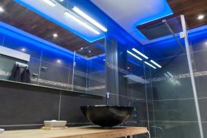 ein Badezimmer mit einer schwarzen Schüssel auf einem Tisch und blauen Lichtern in der Unterkunft Cocoon'Inn Toulouse in Toulouse