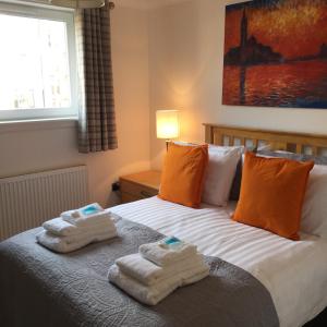 a bedroom with towels on a bed with a window at The Botanic Hub West End - 2 Bedrooms in Glasgow