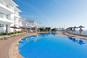 une grande piscine bleue à côté d'un hôtel dans l'établissement HSM Calas Park, à Calas de Mallorca