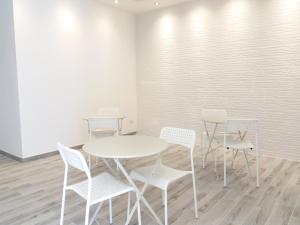 a white table and chairs in a room at Diana's in Stintino +23 photos