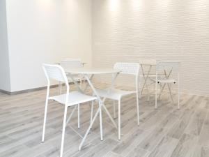a white table and four white chairs in a room at Diana's in Stintino