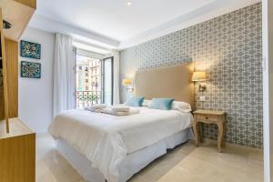 a bedroom with a large bed and a window at Apartamento Living By Cathedral in Seville