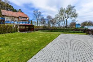 una casa con un cortile erboso accanto a un edificio di Juodkrantes apartamentai a Juodkrantė
