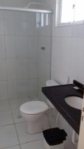 a white bathroom with a toilet and a sink at Hotel Brisa do Aracati in Aracati