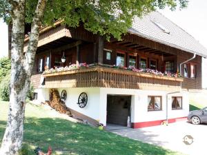 ein Haus mit einem Balkon mit Blumen darauf in der Unterkunft Ferienwohnungen Duffner in Schonach