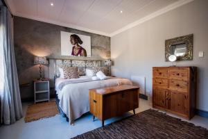 ein Schlafzimmer mit einem Bett und einer Holzkommode in der Unterkunft A Hilltop Country Retreat in Swellendam