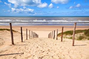 a row of wooden posts on a beach near the ocean at Hotel Astoria in Noordwijk aan Zee