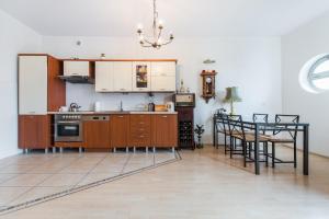 ソポトにあるMW Apartamenty - MONTE CASSINOのキッチン(木製キャビネット、ダイニングテーブル付)