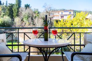 a table with two glasses of wine on a balcony at Iremia in Kariá