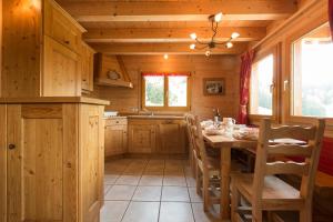 eine Küche mit einem Tisch und Stühlen in einer Hütte in der Unterkunft Les Chalets du Danay in Saint-Jean-de-Sixt