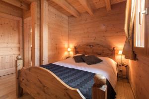 ein Schlafzimmer mit einem Bett in einem Blockhaus in der Unterkunft Les Chalets du Danay in Saint-Jean-de-Sixt