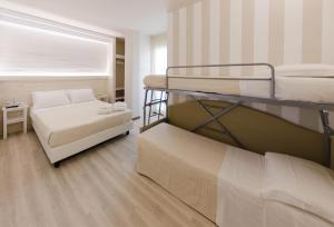 Habitación pequeña con 2 literas y sofá en Mona Lisa Hotel, en Cattolica